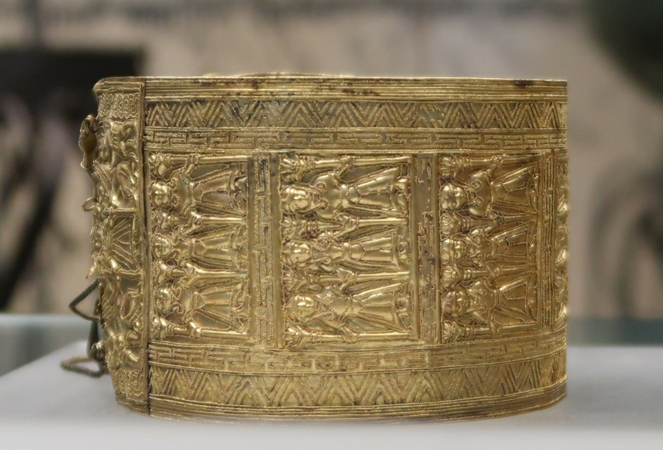 Bracelet en or. Or poli et fondu, décoré en repoussé et granulation long. cm 26 ; larg. cm 6,7/6,9 ; diam. cm 9,3/10